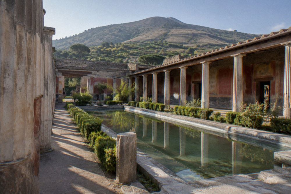 Frescoed wall of an ancient Roman villa interior with painted architecture in red and blue