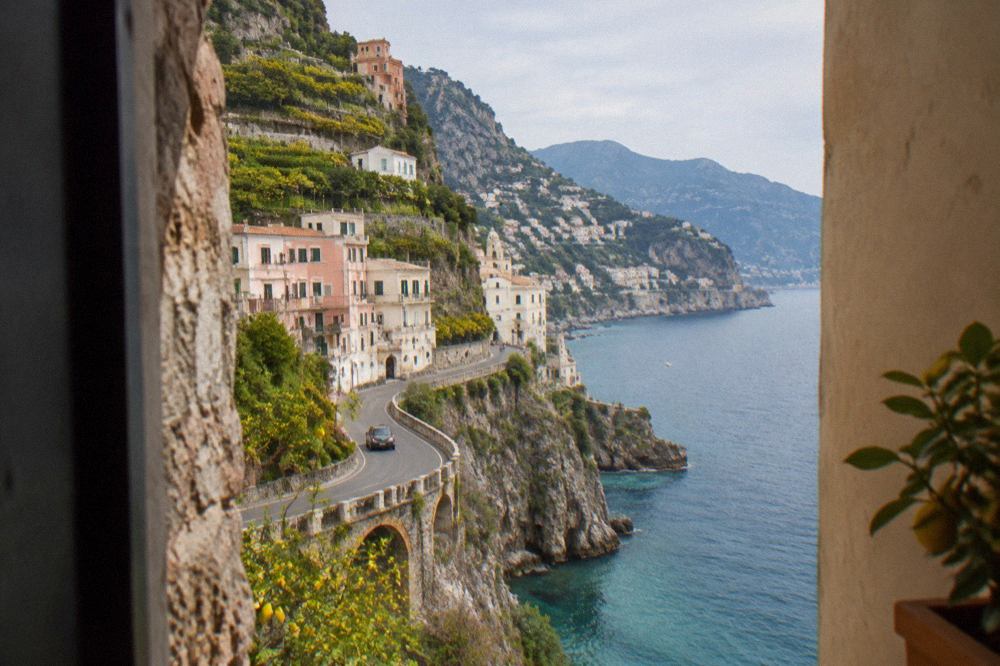 Pastel-coloured houses rising steeply from a narrow beach on the Amalfi Coast