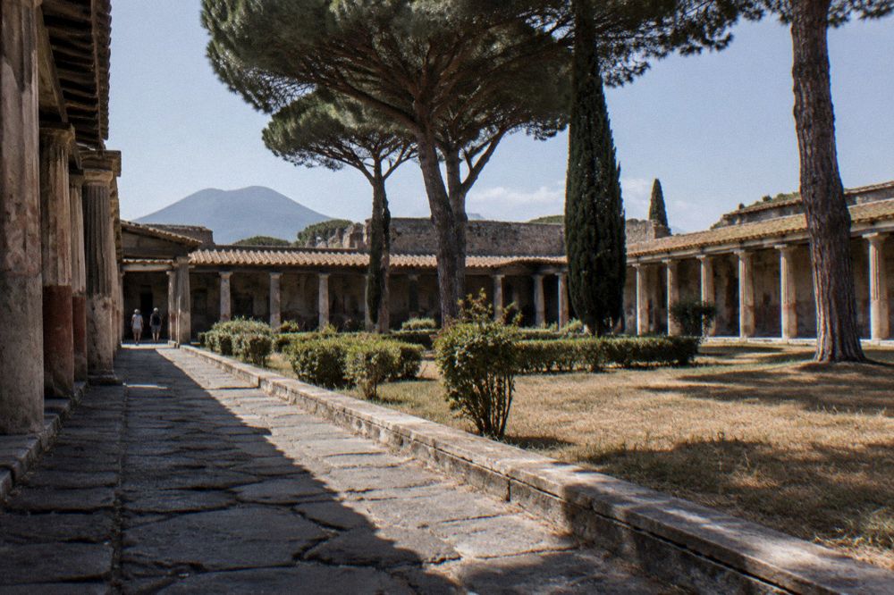 Stone stepping stones crossing a worn Roman street in Pompeii with wheel ruts in the paving