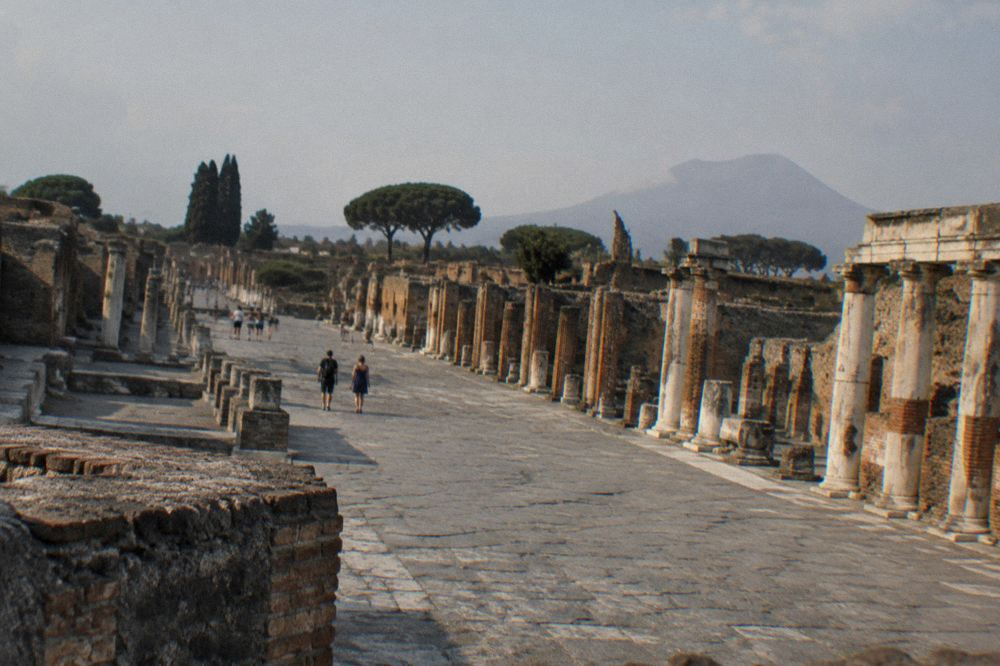 The forum of Pompeii at golden hour with column bases and Vesuvius on the horizon