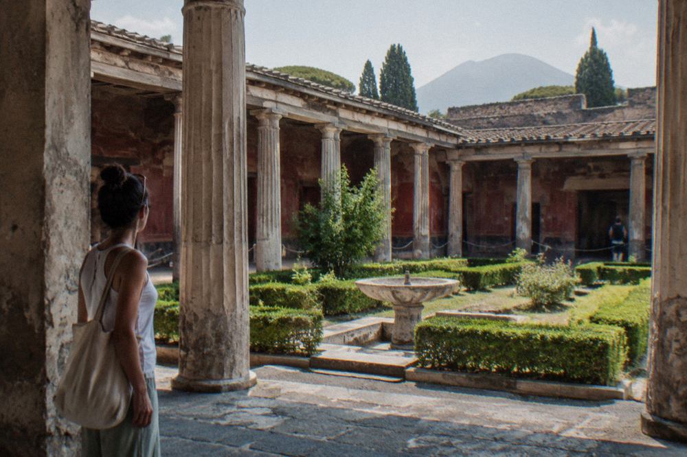 Stone street of ancient Pompeii with worn wheel ruts and broken columns under a clear sky
