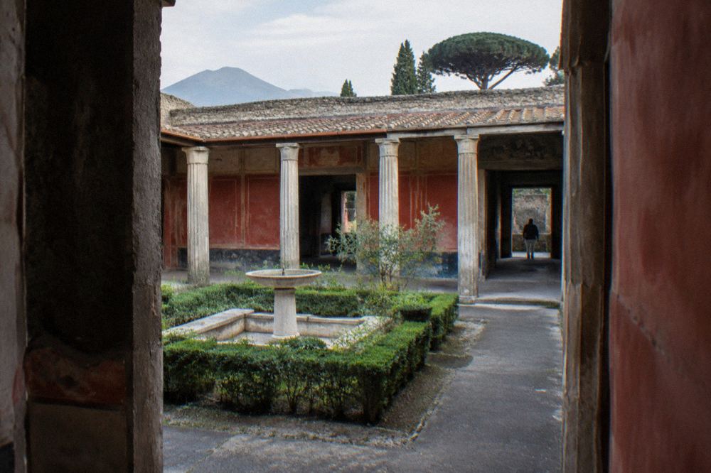 Weathered plaster wall with traces of ancient painted decoration inside a Pompeian ruin