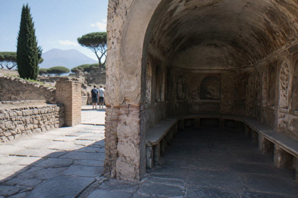 Stone street in the excavated Roman city of Pompeii with ancient walls under open sky