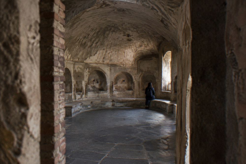 Exposed stone wall with faded ancient painted inscription in Pompeii