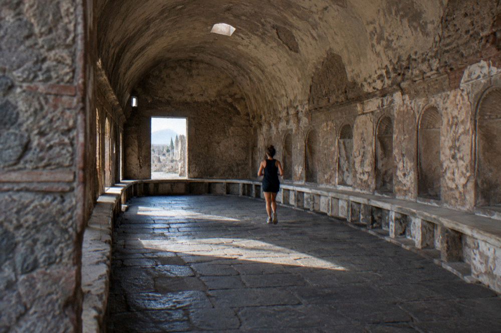 Queue of visitors at a stone entrance gate of the Pompeii archaeological park