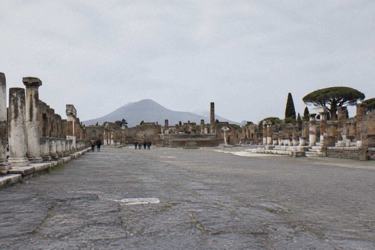Stone street in the excavated Roman city of Pompeii with ancient walls under open sky