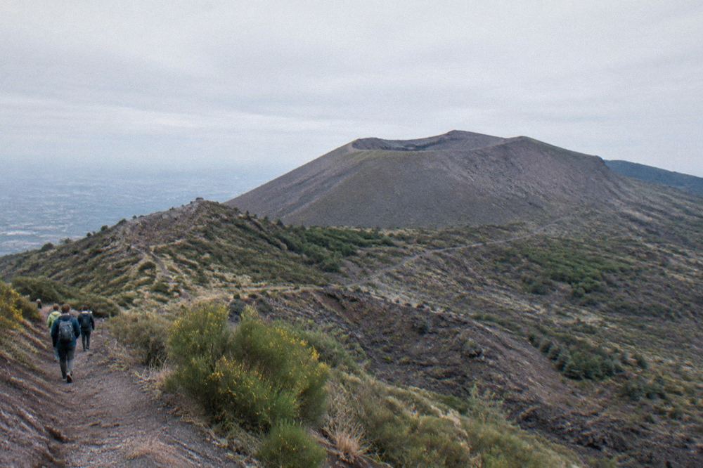 A timed entry queue at a mountain trailhead barrier in morning light