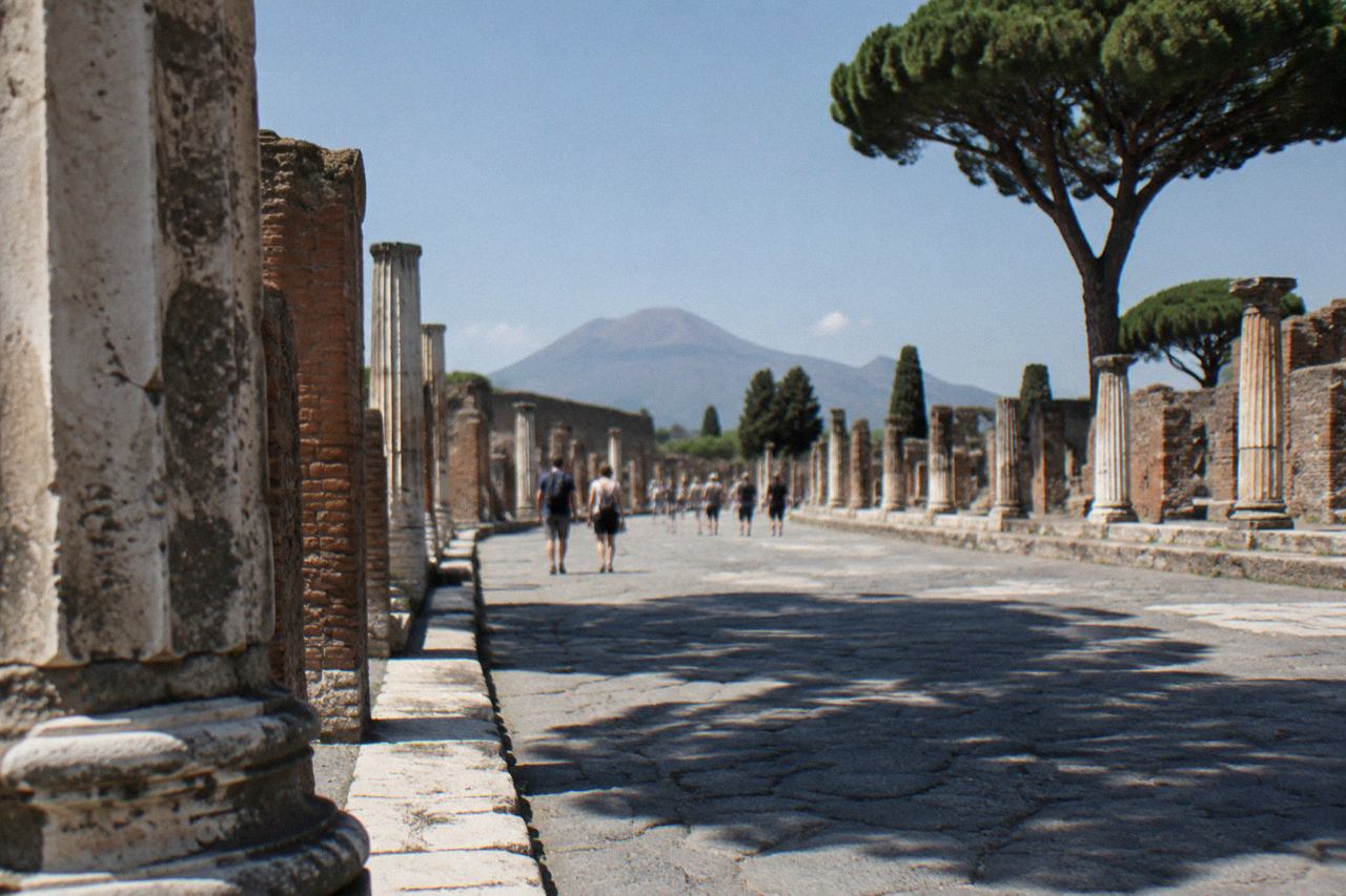 Ancient stone street in Pompeii with worn stepping stones and ruined walls under a clear sky
