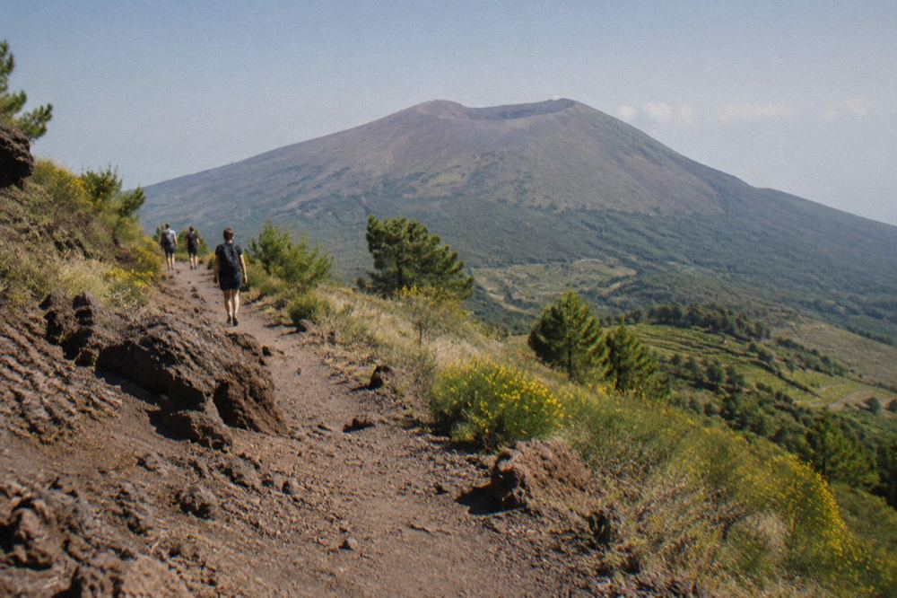 Walking boots on loose volcanic gravel beside the crater trail on Vesuvius