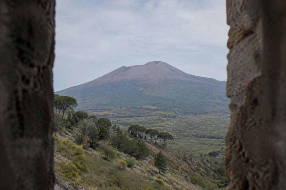 The excavated stone streets of Pompeii with the profile of Vesuvius on the horizon