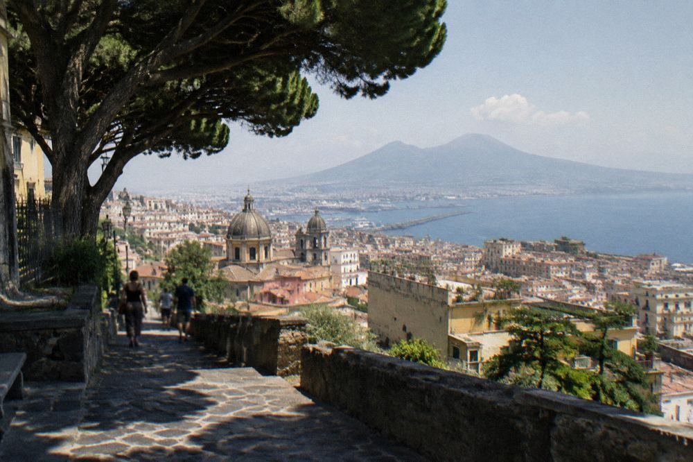 A ticket entrance at Pompeii with ancient stone walls and visitors passing through