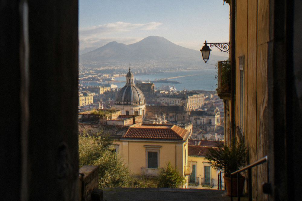 A busy narrow street in Naples old town with hanging laundry and old buildings