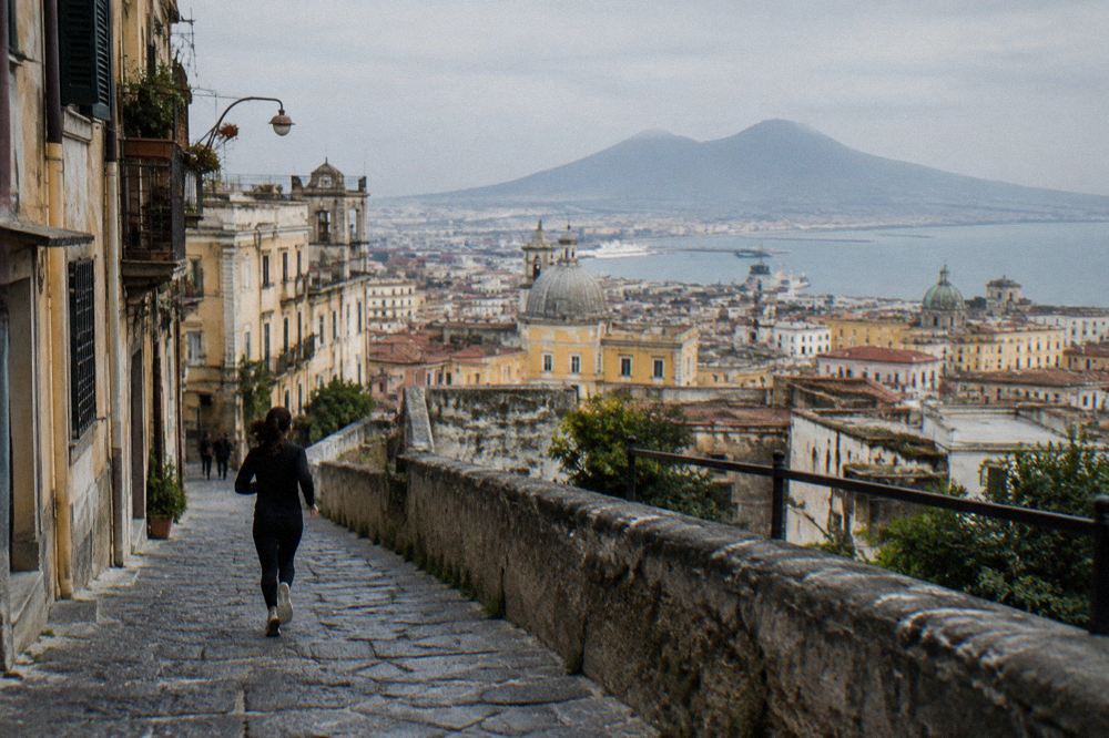 The view from a Sorrento hotel terrace at sunset with the Bay of Naples and Vesuvius silhouetted against an orange sky