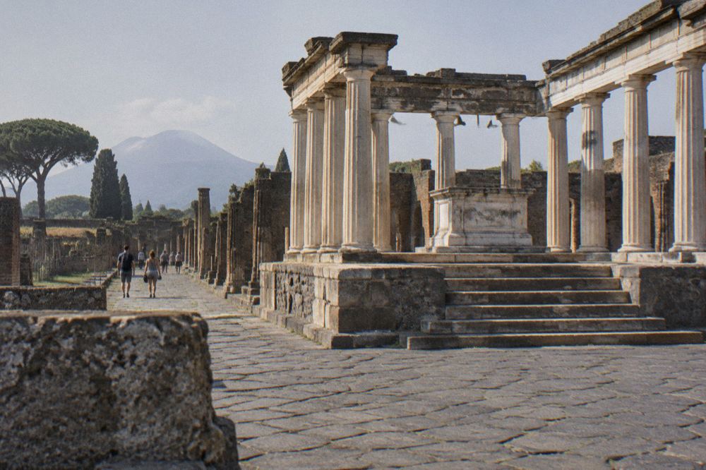 An ancient amphitheatre terrace in Pompeii with grass banks and ruined arches