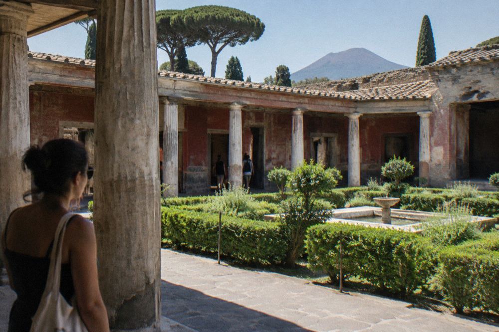 A quiet ancient lane in Pompeii with worn stone paving and low ruined walls