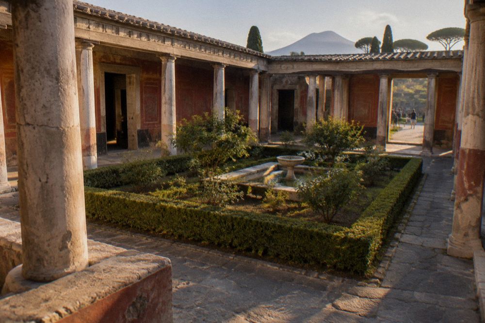 Ancient Pompeii columns against morning light with long shadows on stone paving