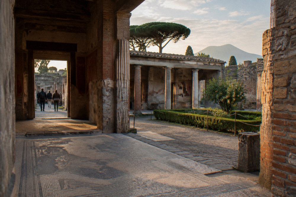 Ancient stone street in Pompeii with worn stepping stones and weathered walls under a clear sky