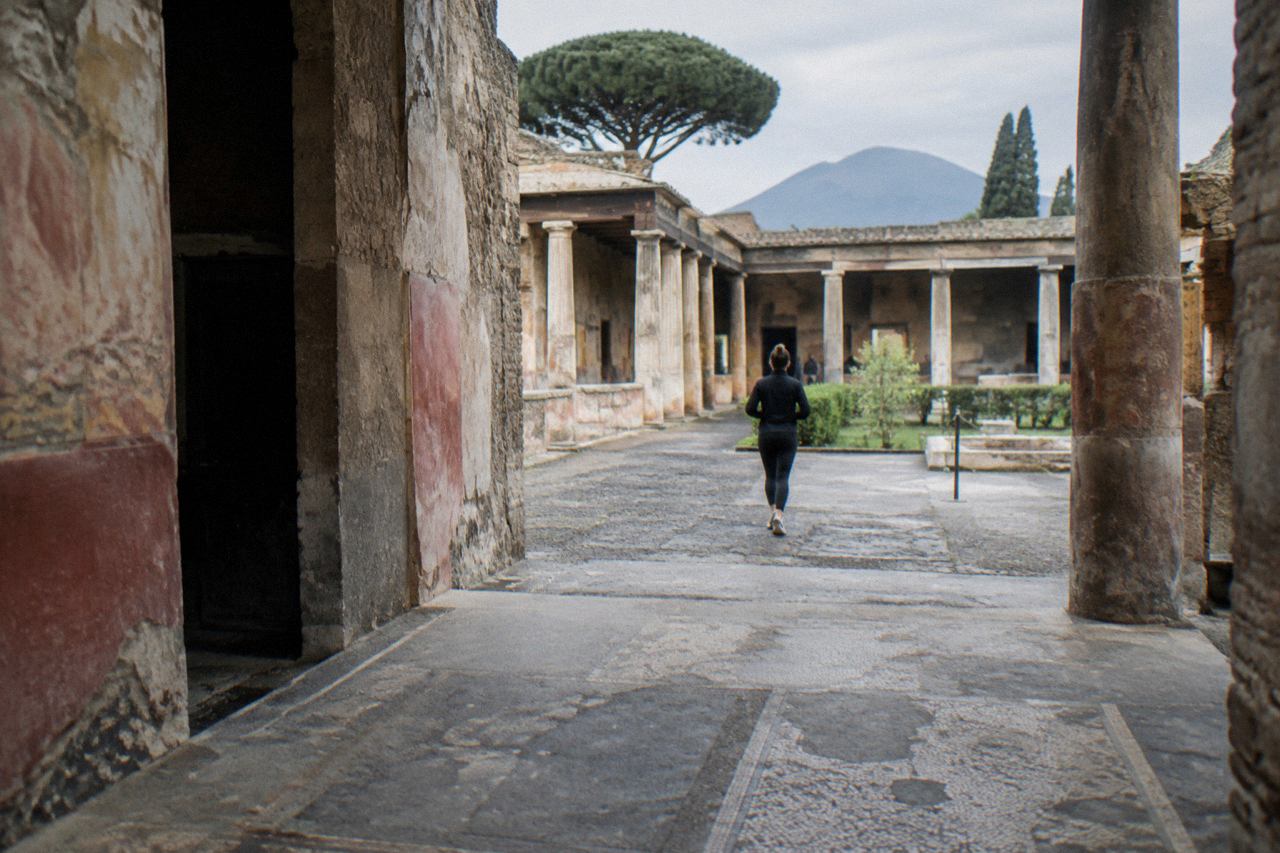 Ancient stone street in Pompeii with worn stepping stones and weathered walls under a clear sky
