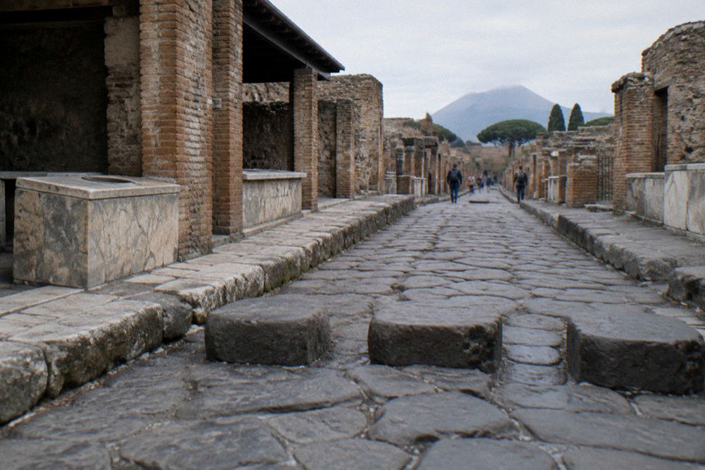 A plaster cast displayed beside ancient stone walls under a shelter at the Pompeii archaeological park
