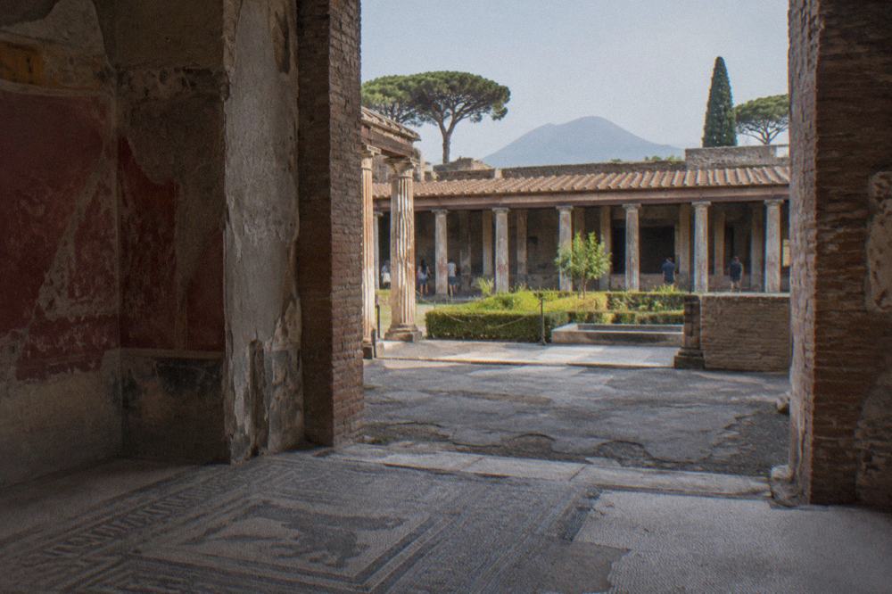 Grass-covered arena of the ancient Pompeii amphitheatre ringed by stone seating tiers