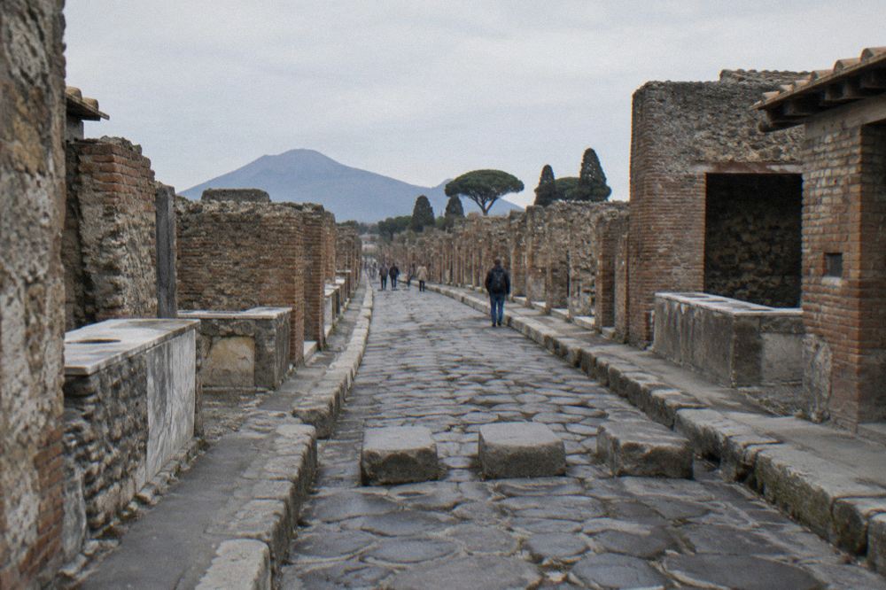 Stepping stones crossing an ancient paved street beside a stone fountain