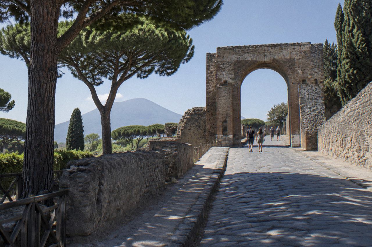 Ancient stone street in Pompeii with worn stepping stones and weathered walls under a clear sky