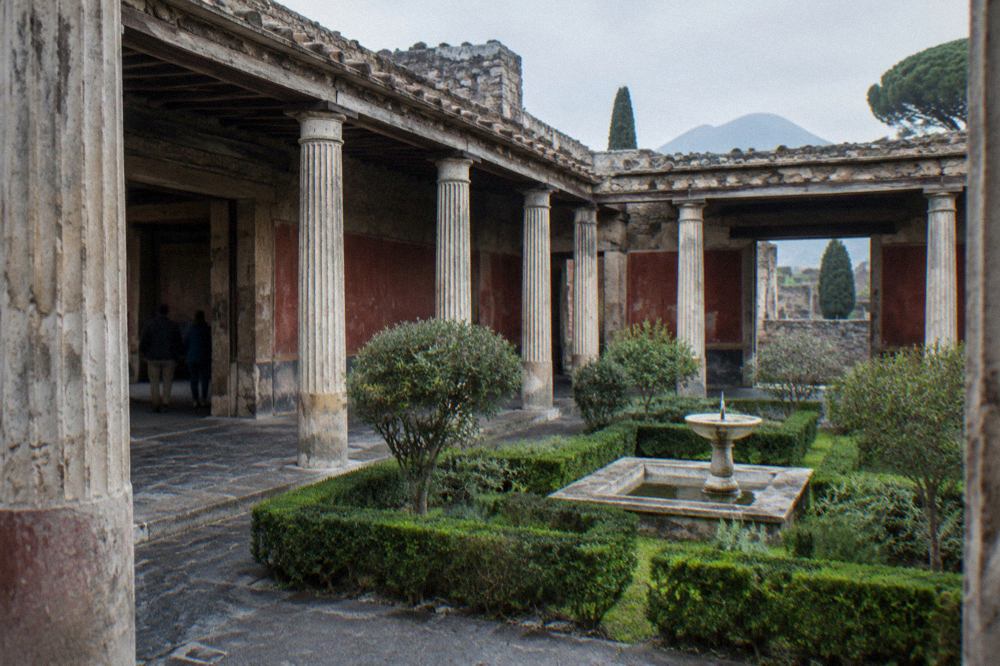 Ancient stone street in Pompeii with worn stepping stones and ruined walls under a clear sky