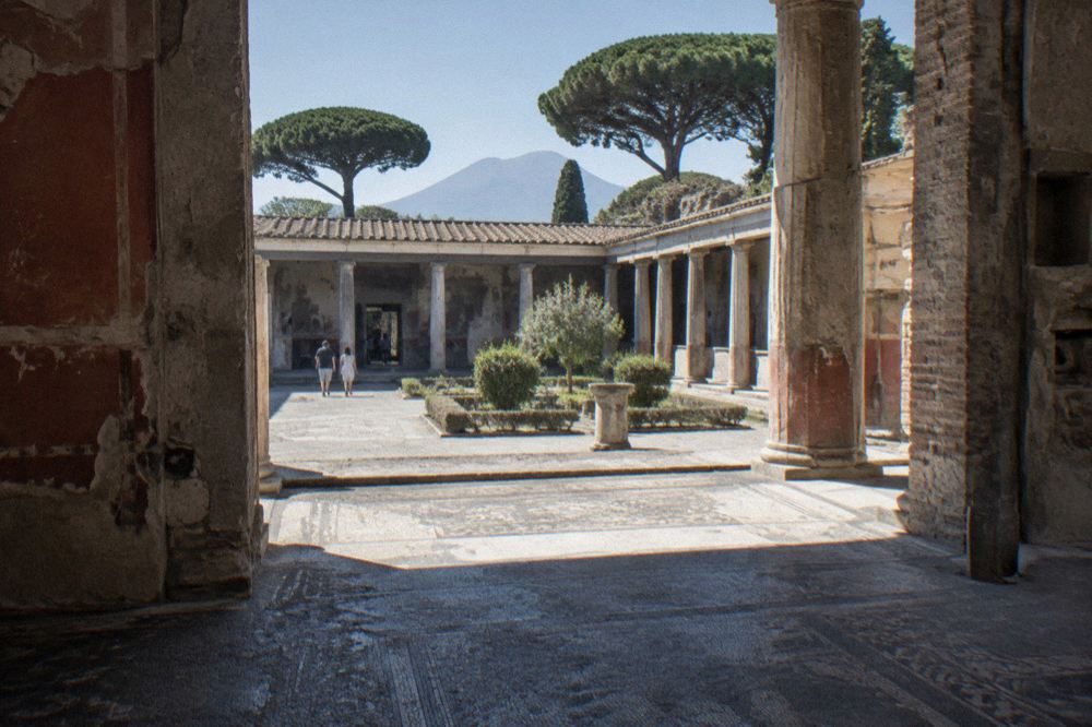 Stone amphitheatre arena at Pompeii with grass centre and tiered seating rows