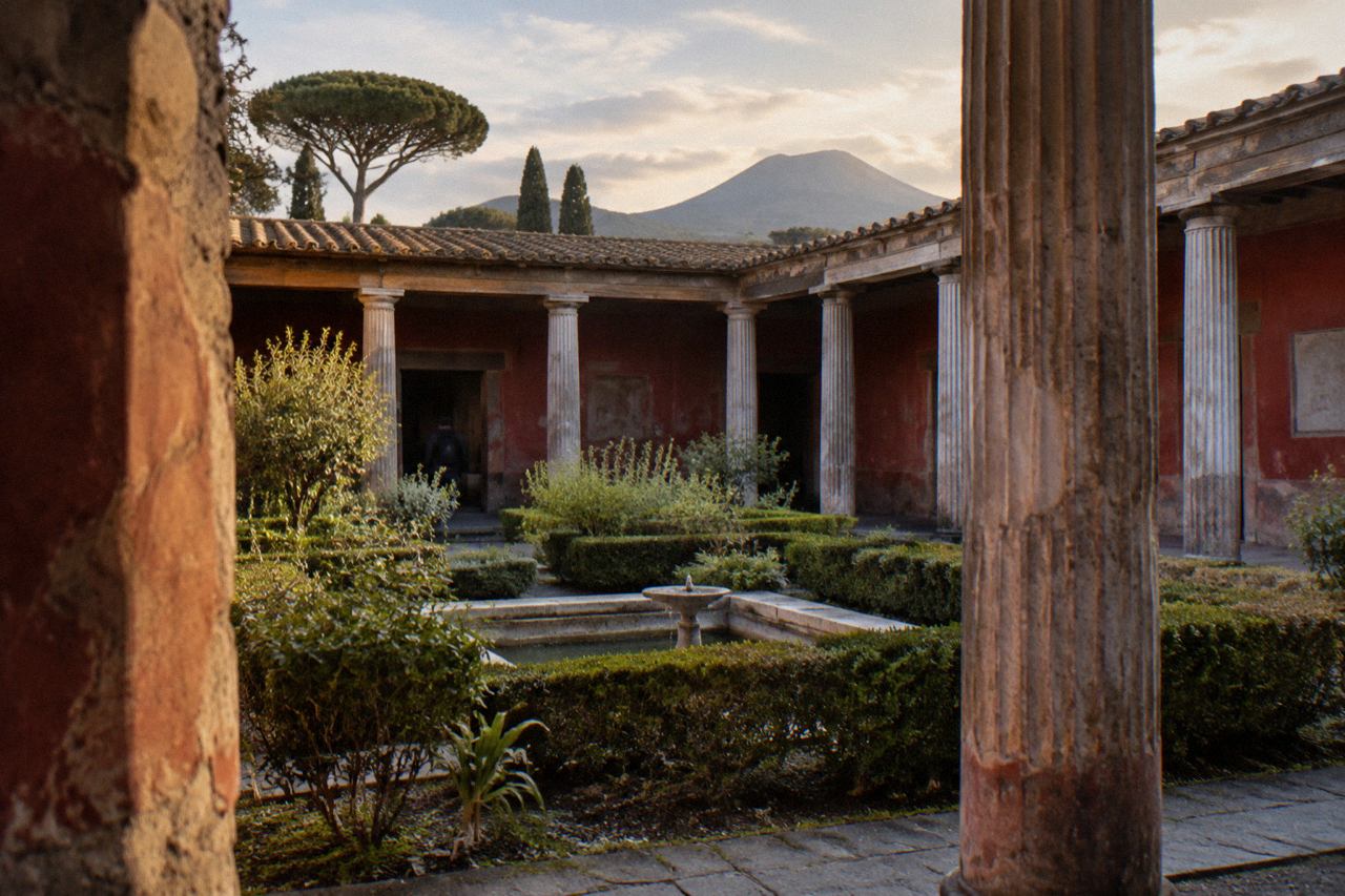 Ancient stone street in Pompeii with worn stepping stones and ruined walls under a clear sky