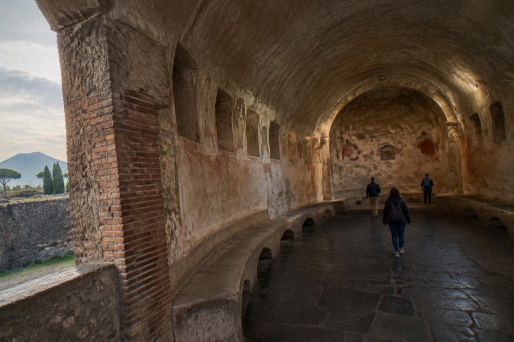 Wide view of Pompeii ruins with Mount Vesuvius rising in the background