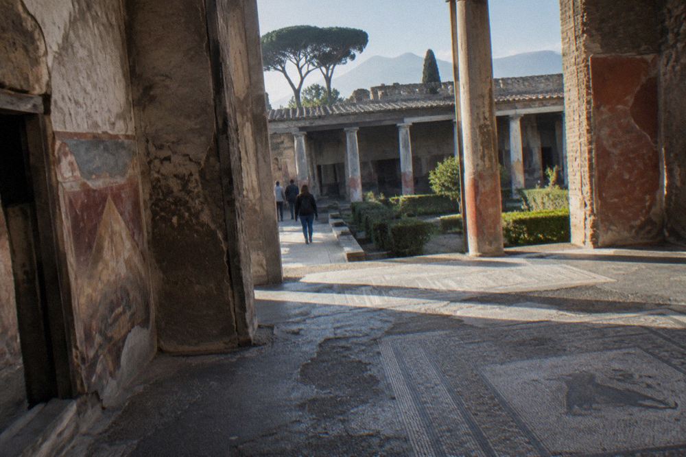 Stepping stones crossing an ancient paved street in Pompeii with worn cart ruts