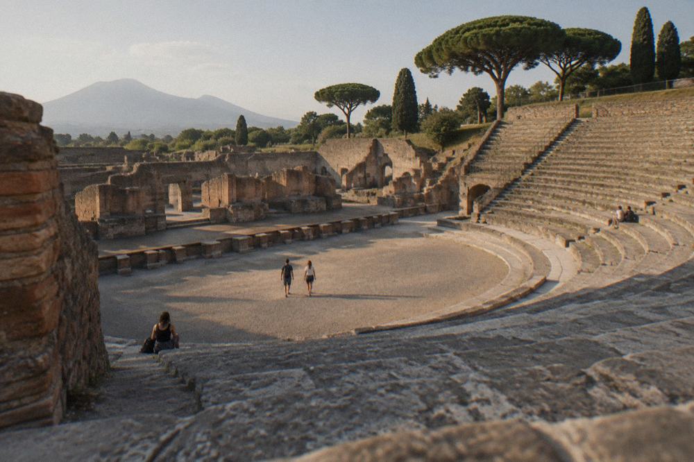 Rows of ruined Pompeii walls and columns stretching toward distant hills