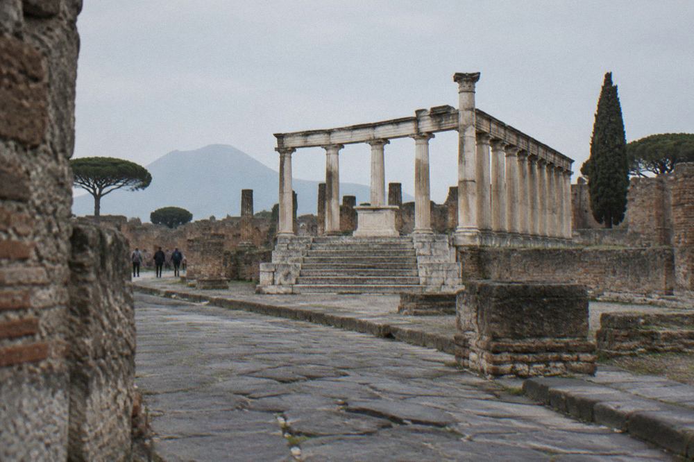 Wide view over the excavated ruins of Pompeii with Mount Vesuvius rising in the background