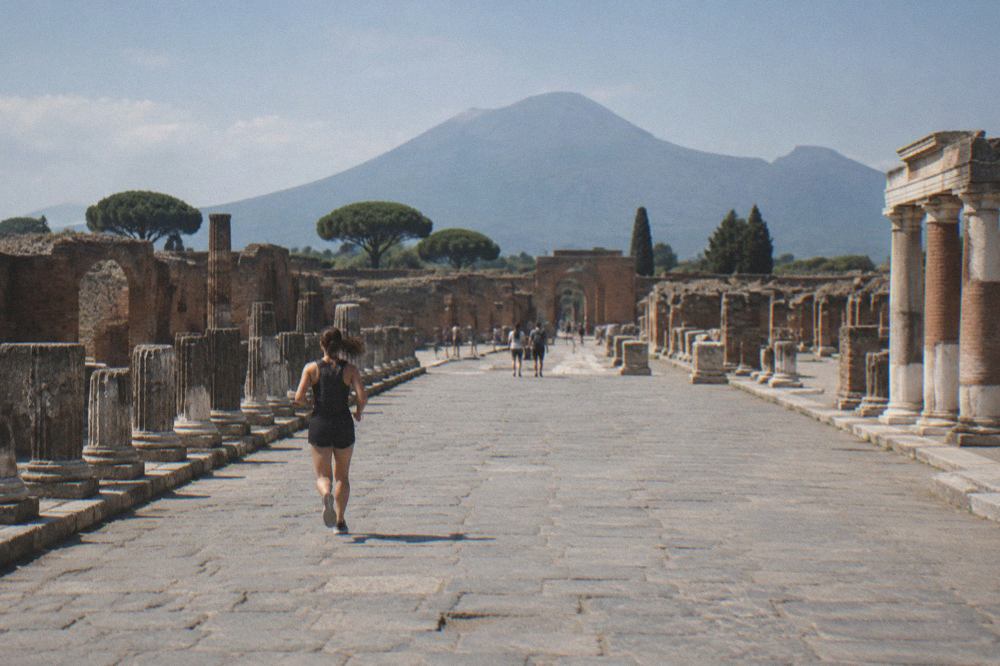 Ancient stone-paved street in Pompeii with ruined walls on both sides