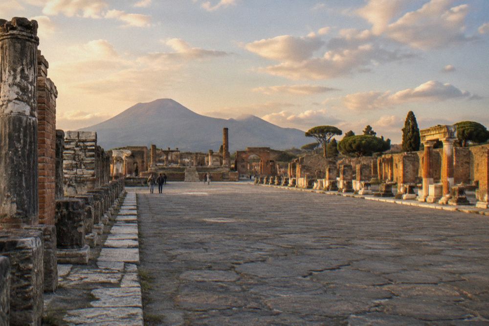 Vineyard rows on the slopes of Vesuvius at dusk with the volcano ridge behind