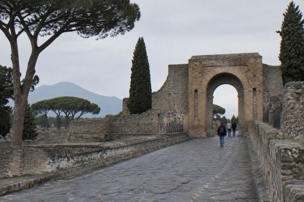 Guided group walking through a paved Pompeii street with a guide speaking