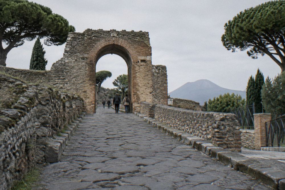 Empty excavated courtyard of a Pompeii house in late afternoon shadow