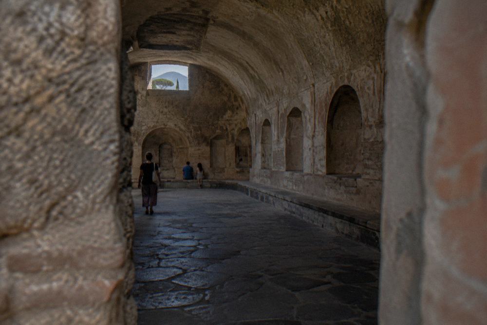An ancient stone-paved Roman street inside Pompeii with worn cart ruts