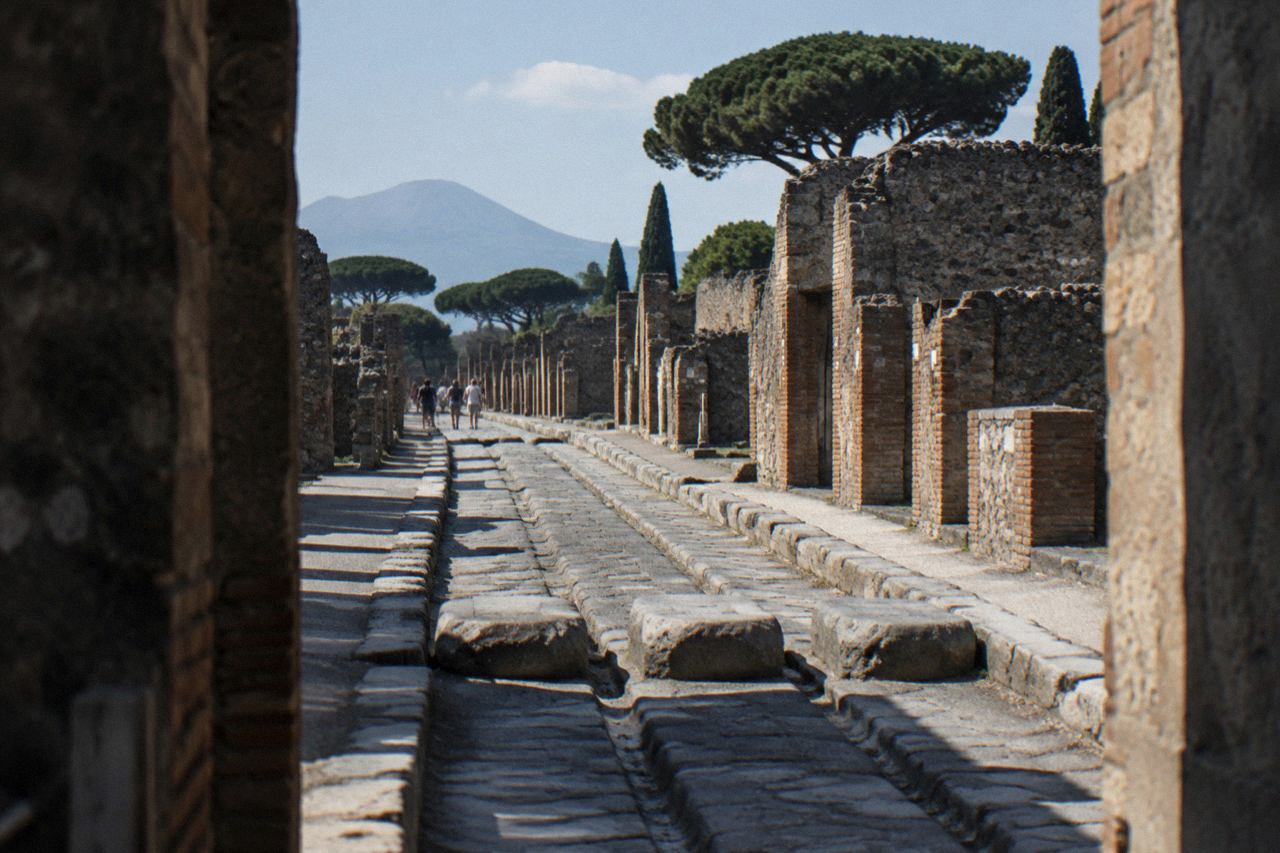Ancient stone street in the archaeological park of Pompeii with worn stepping stones and ruts in the paving