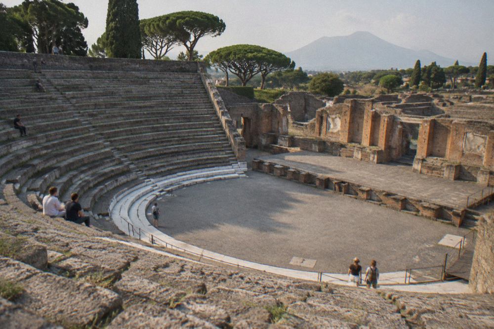The ruins of Pompeii with the peak of Mount Vesuvius rising in the background under a clear sky