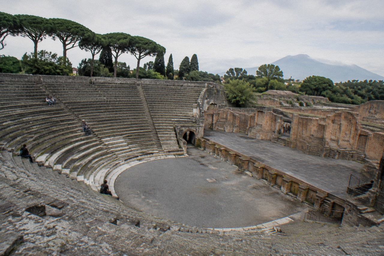 The ruins of Pompeii with the peak of Mount Vesuvius rising in the background under a clear sky