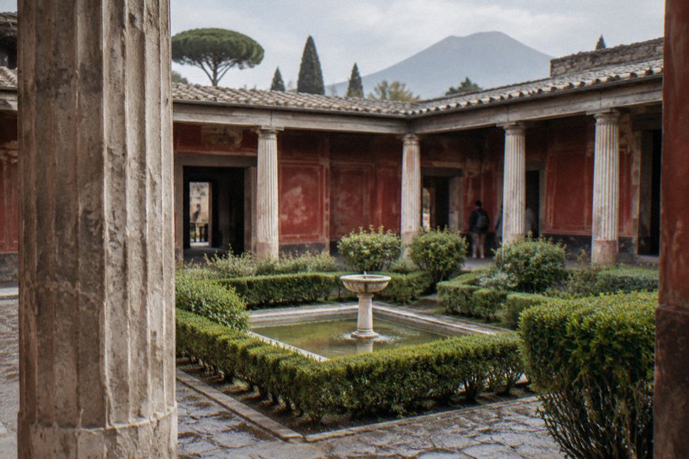 Ticket office entrance area at Pompeii with visitors gathering beside the ancient walls