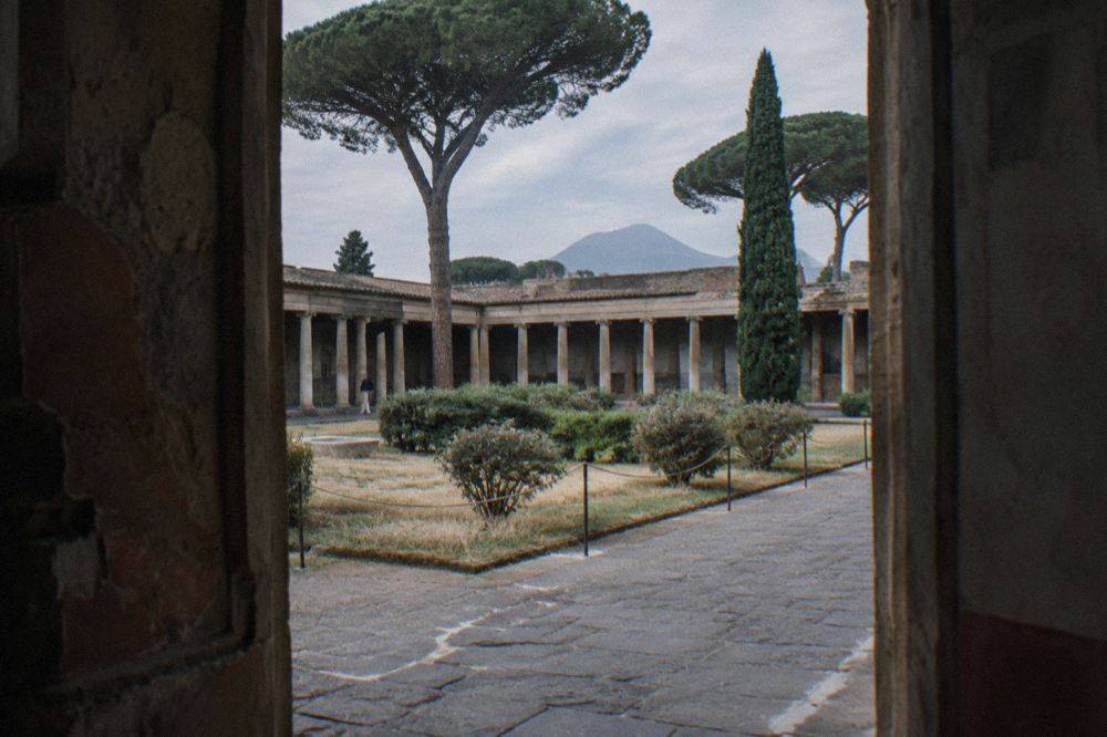 A modern service building beside the ancient stone walls inside Pompeii