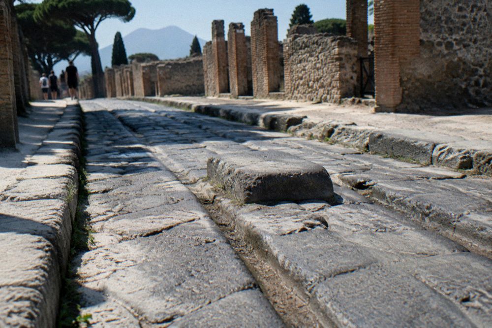 A pair of walking shoes and a water bottle on a stone bench at Pompeii