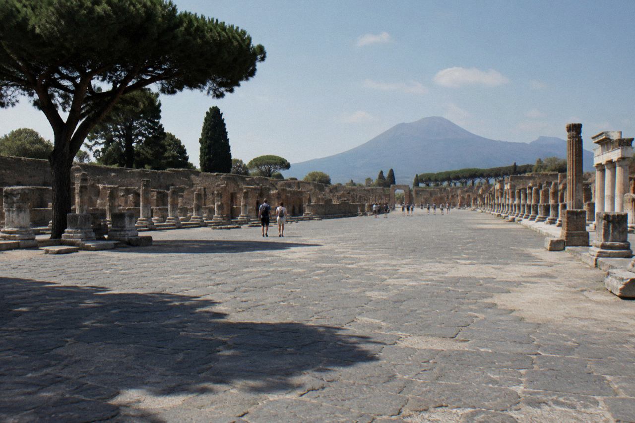 Ancient stone Roman latrine seats along a wall of the Pompeii archaeological site
