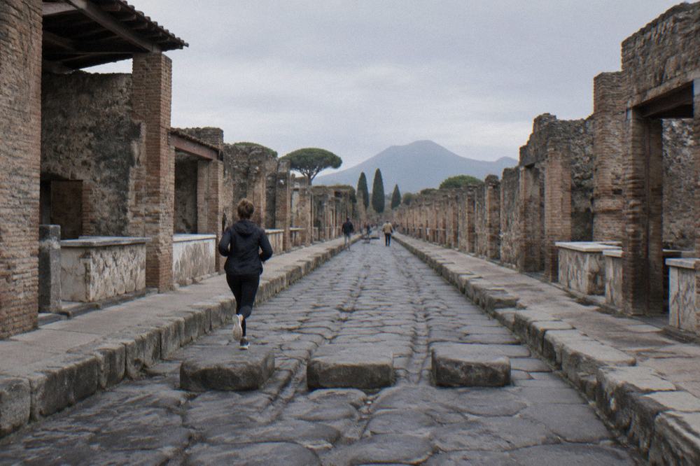 Stone gateway of an ancient entrance with worn steps and worn ruts in the paving