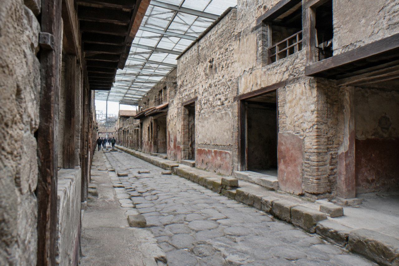 Stone-paved Roman street with ancient walls under an open sky at an archaeological site in Campania