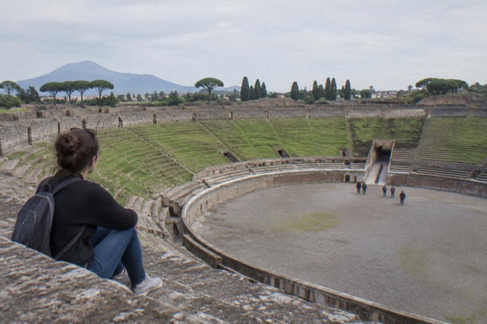 Wide view of Pompeii ruins with Mount Vesuvius rising behind the ancient walls