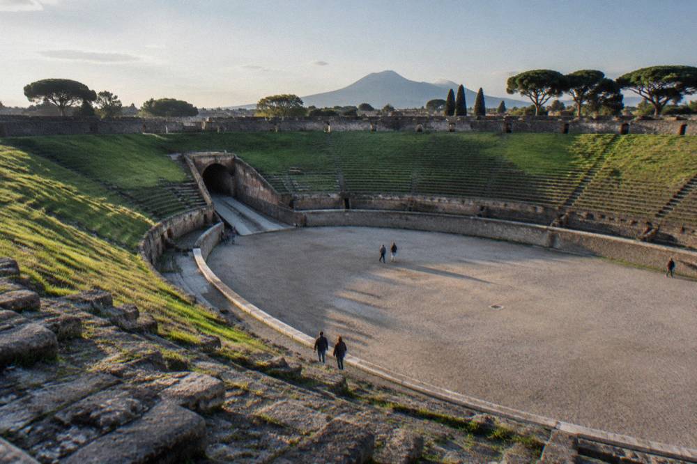 A tour group walking along an ancient stone street in Pompeii with a guide