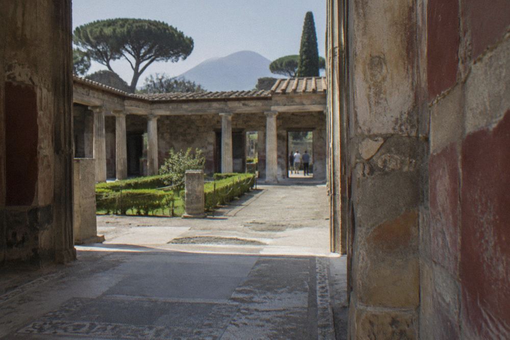 Column-lined open square of the Roman Forum with Mount Vesuvius rising behind it